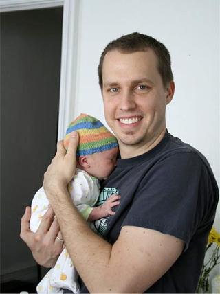 New father Dan Rudloff tries to express joy while realizing he will never ever be able to get that boat.